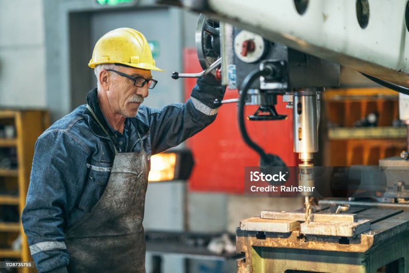 Lavoratore anziano che opera su un macchinario in un&rsquo;officina